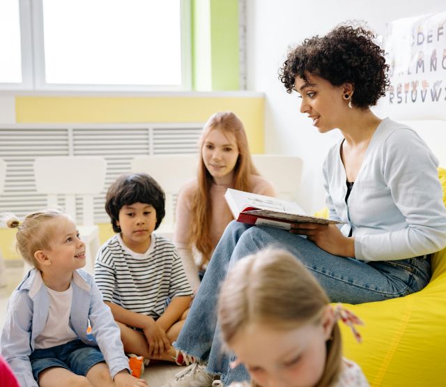 Woman Reading A Book To The Children